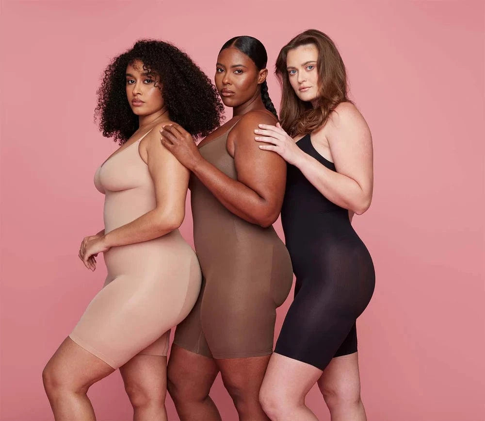 Three women in shapewear, standing together.