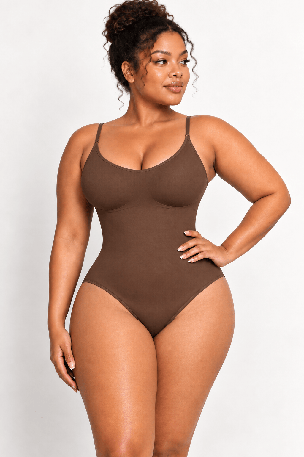 A woman modeling a solid brown bodysuit against a plain light gray studio background.