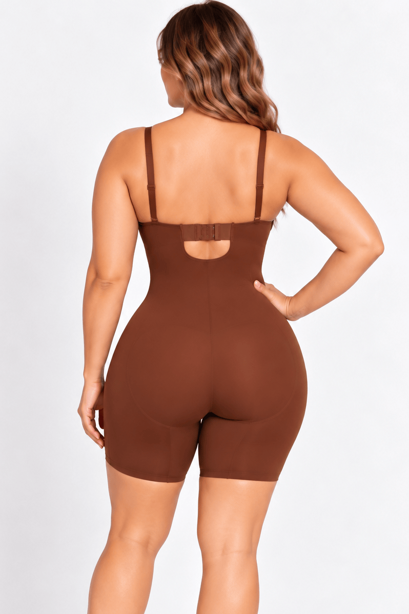 A woman modeling a brown shapewear bodysuit from the back, showing the open back and straps, on a white studio background.